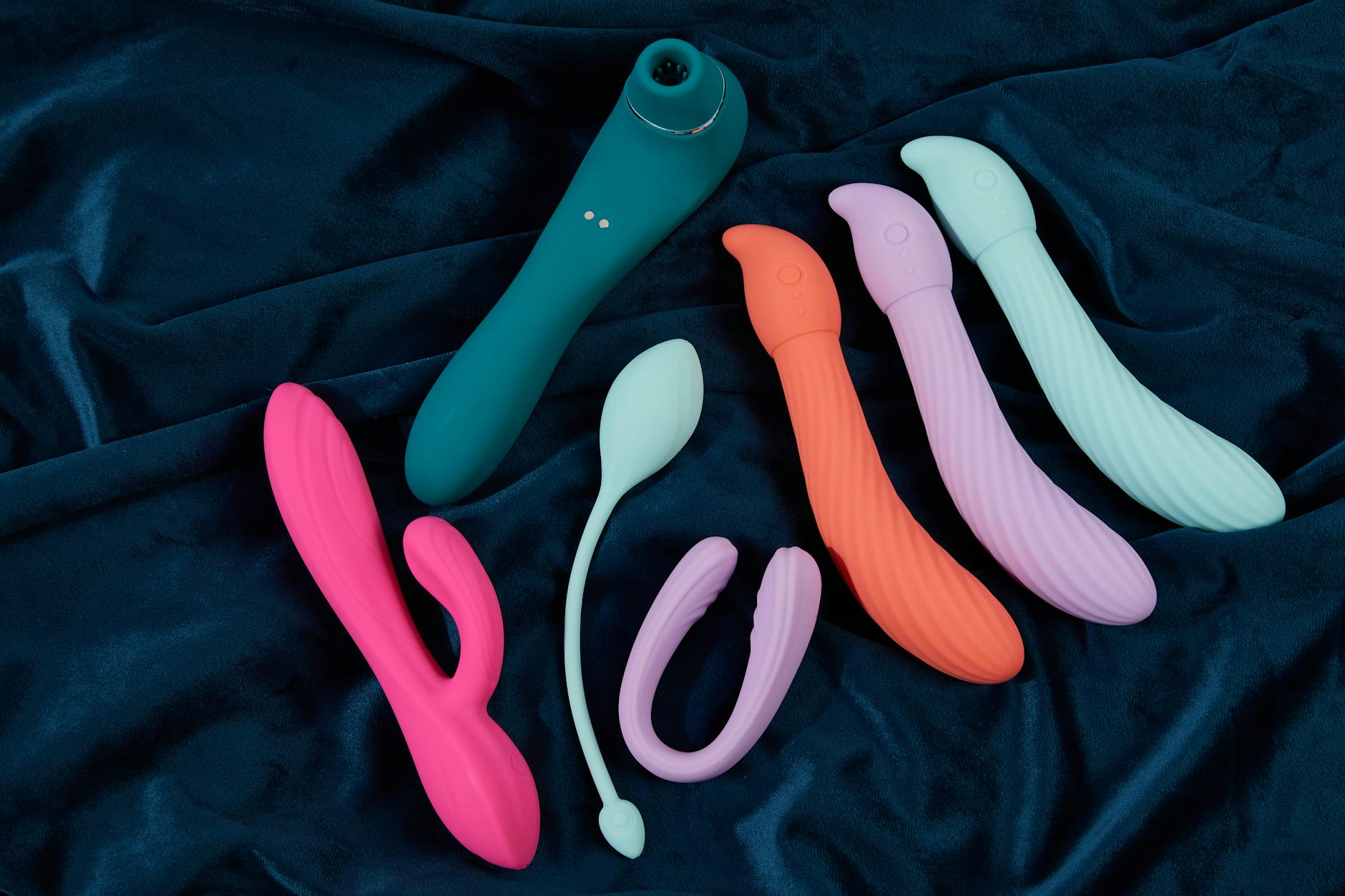 A person holding a basket containing colorful vibrators and a pink flower