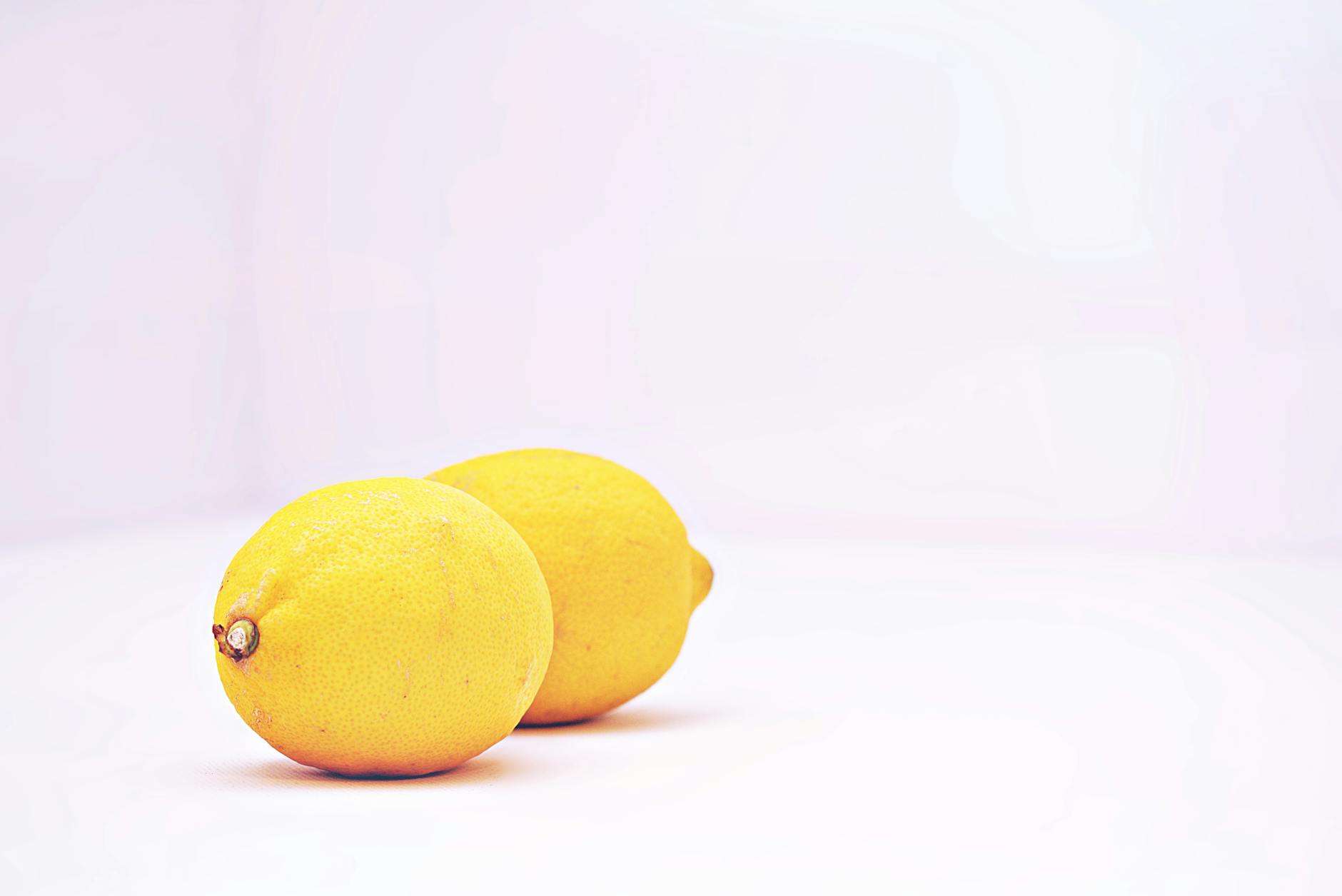 Two vibrant lemons on a white background, symbolizing freshness and the lemon wand brand