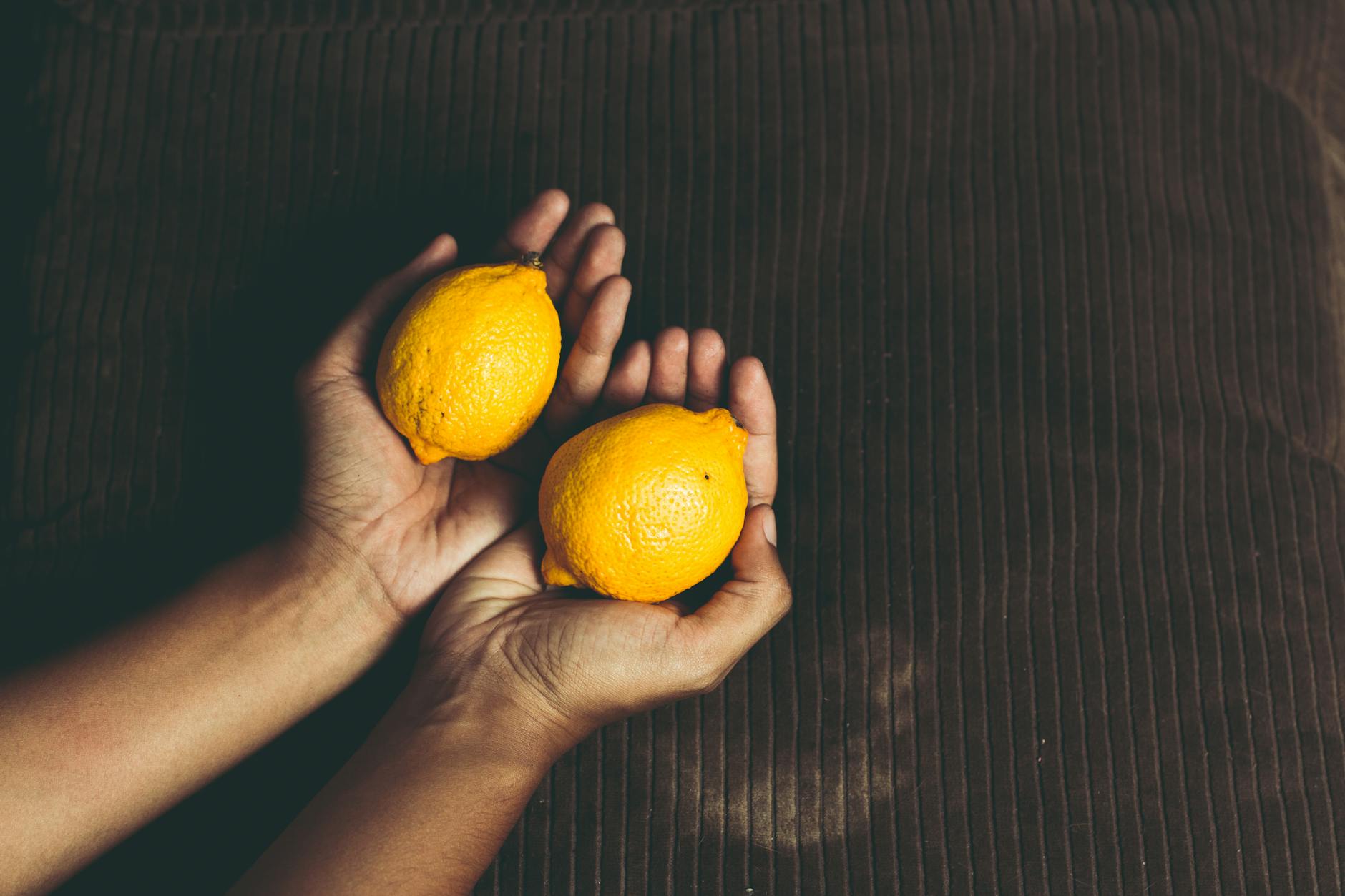 Two hands cupping fresh lemons, symbolizing the shift to a new approach
