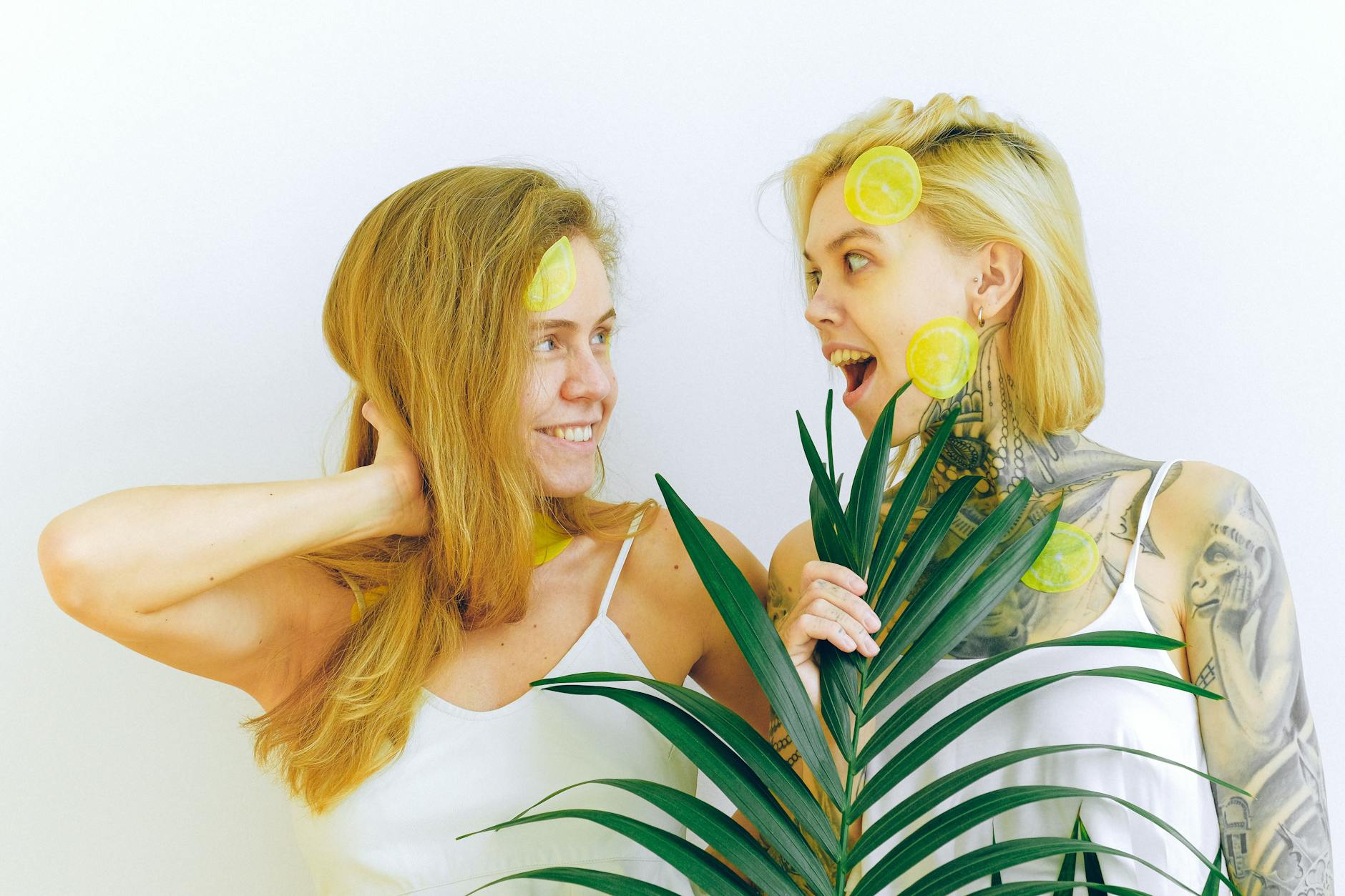 Two women smiling joyfully together indoors, expressing confidence and connection
