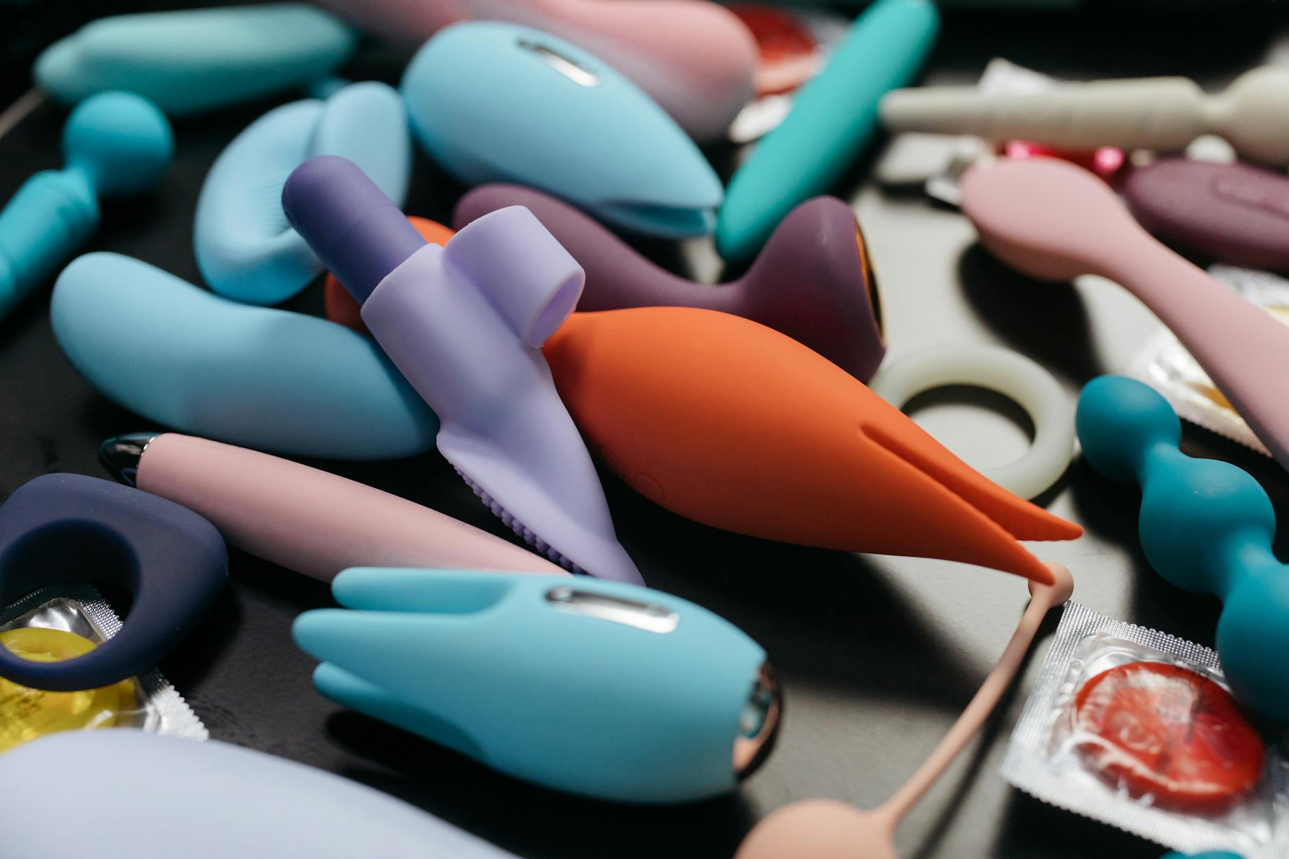 An array of vibrant adult toys including lemon vibrators and rings in a close-up view.